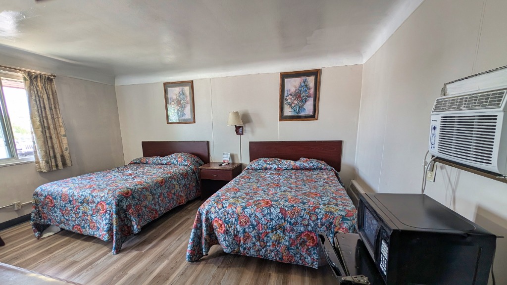 Spacious Deluxe Double Room at Bay Motel featuring two beds and comfortable amenities